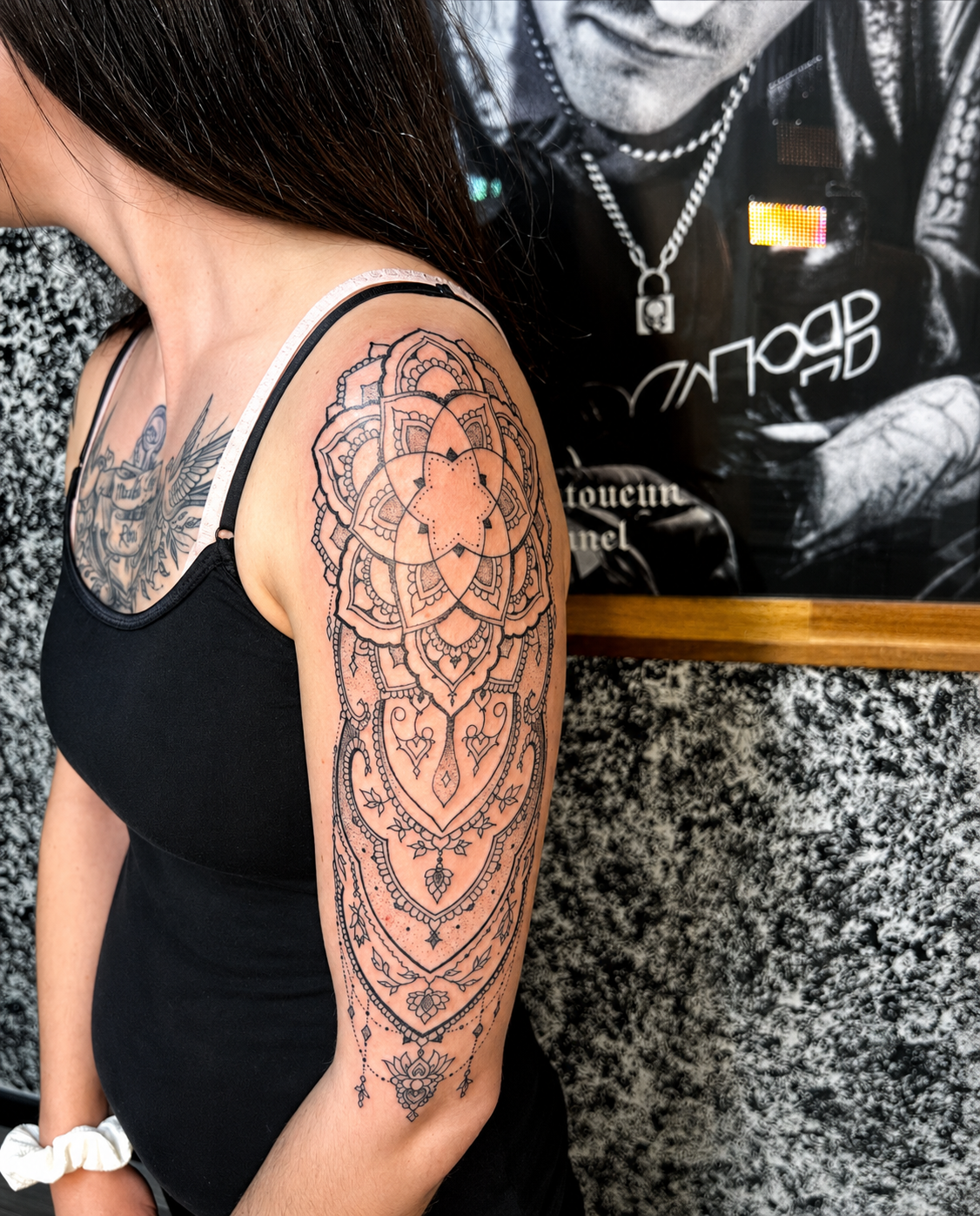 Tatouage mandala fine line noir sur l'épaule et le bras d'une femme, avec motifs ornementaux délicats, réalisé chez KavaDerma à Drummondville.